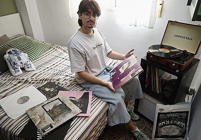 Alejandro Badillo, de 19 años, muestra algunos de sus vinilos, junto a su maletín tocadiscos.