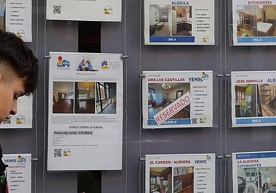 Un joven pasa por delante de una inmobiliaria, en una imagen de archivo.