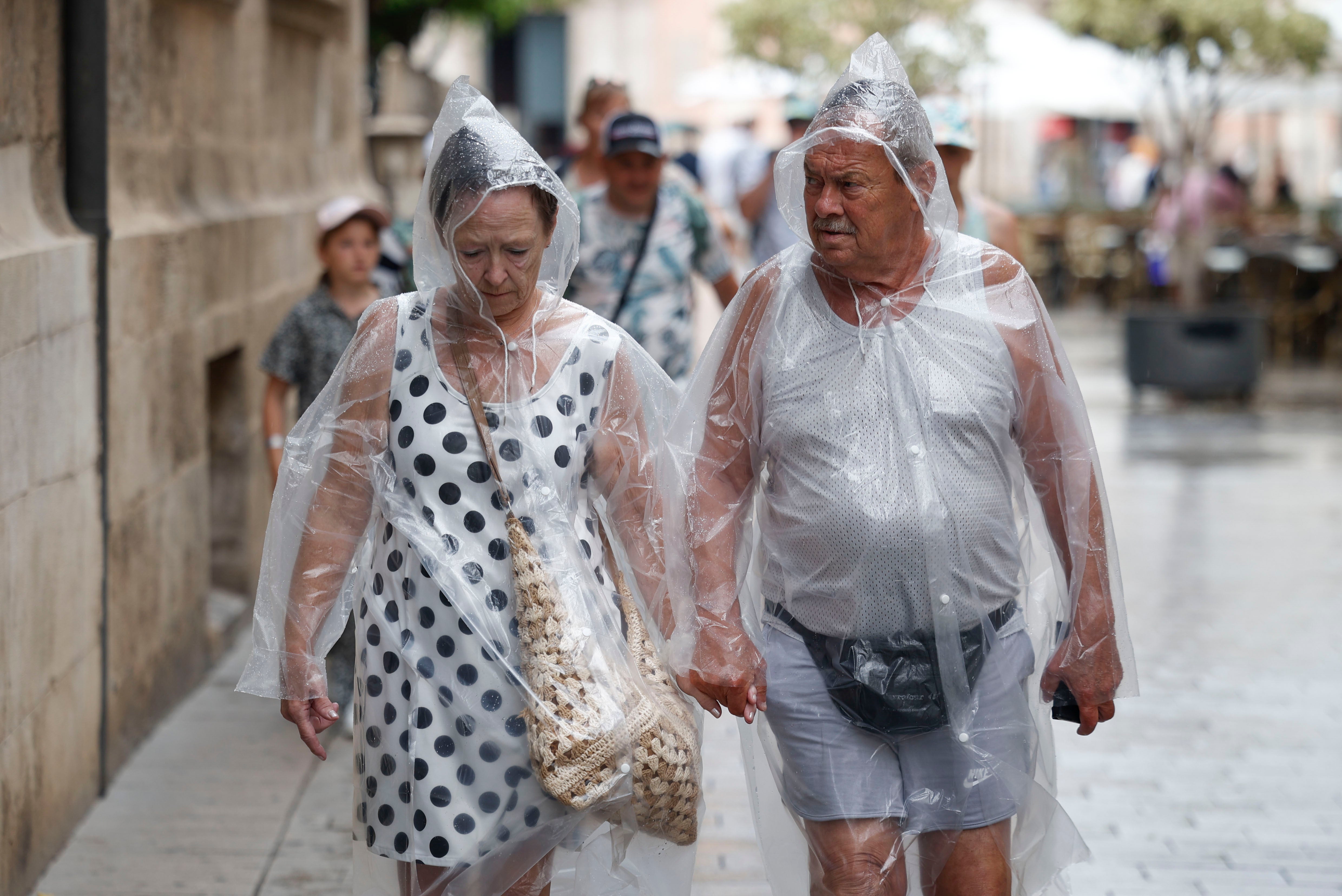 Dos personas se protegen de la lluvia.