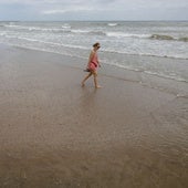 Mujer que pasea por la orilla de Port Saplaya.