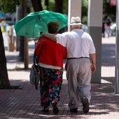Una pareja de jubilados caminan por la calle.