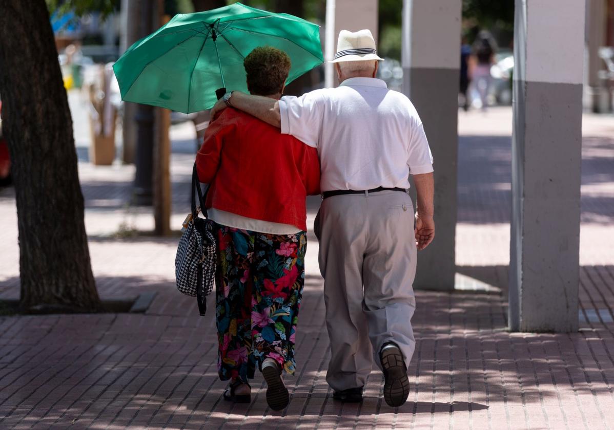 Una pareja de jubilados caminan por la calle.