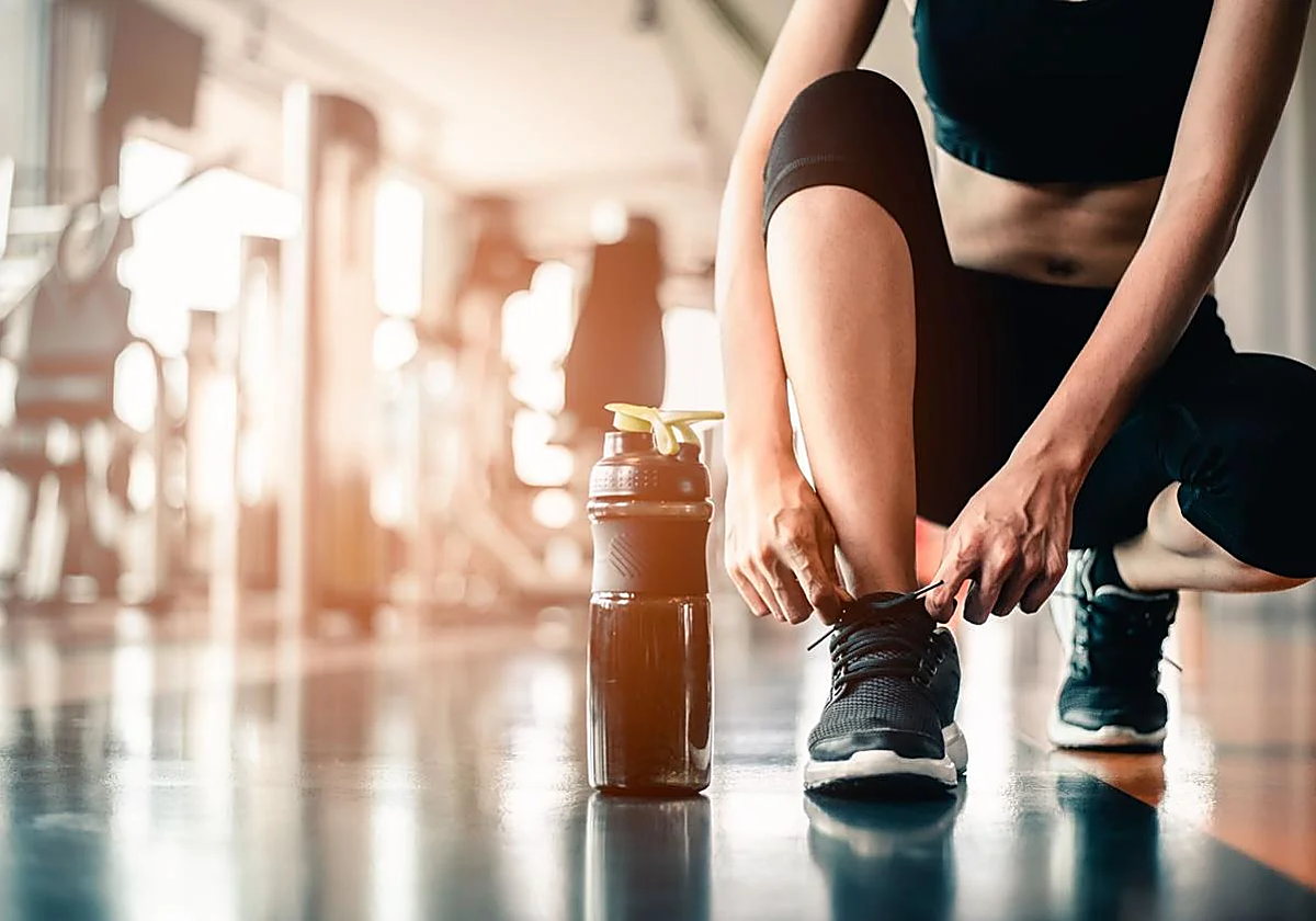 Una mujer se prepara para realizar ejercicio en un gimnasio.