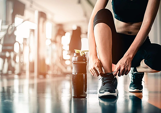 Una mujer se prepara para realizar ejercicio en un gimnasio.
