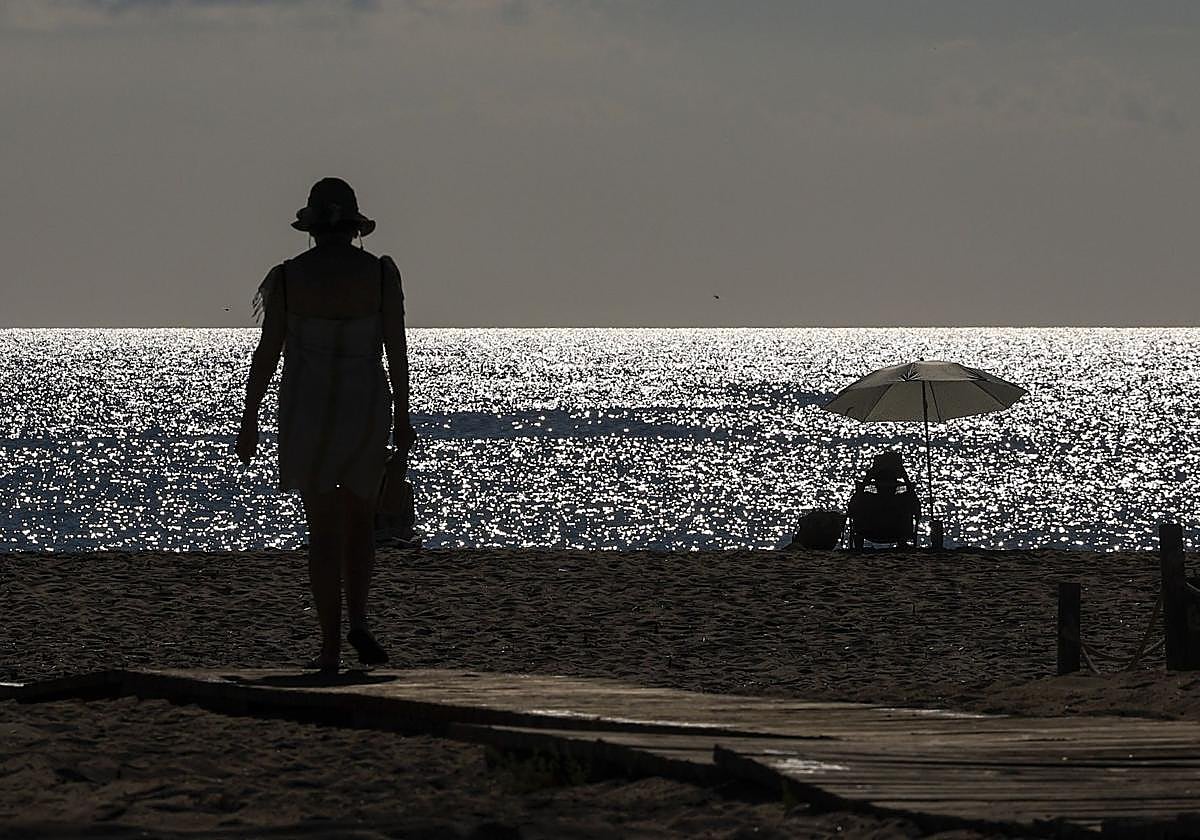 Dos personas disfrutan del calor en la playa.