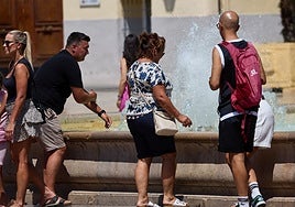 Varias personas se refrescan en una fuente este domingo en Valencia.