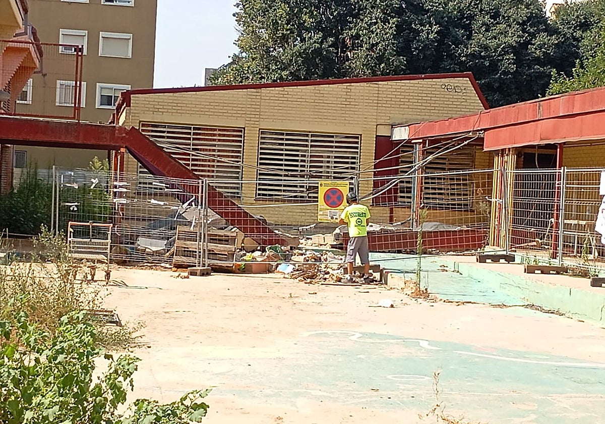 Un operario coloca vallas alrededor del techado del colegio Lluís Vives de Massanassa.