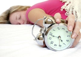 Mujer sujetando un despertador