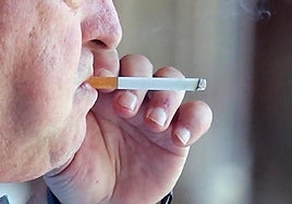 Un hombre fuma un cigarro.