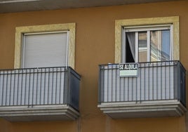 Edificio con un cartel de se alquila.