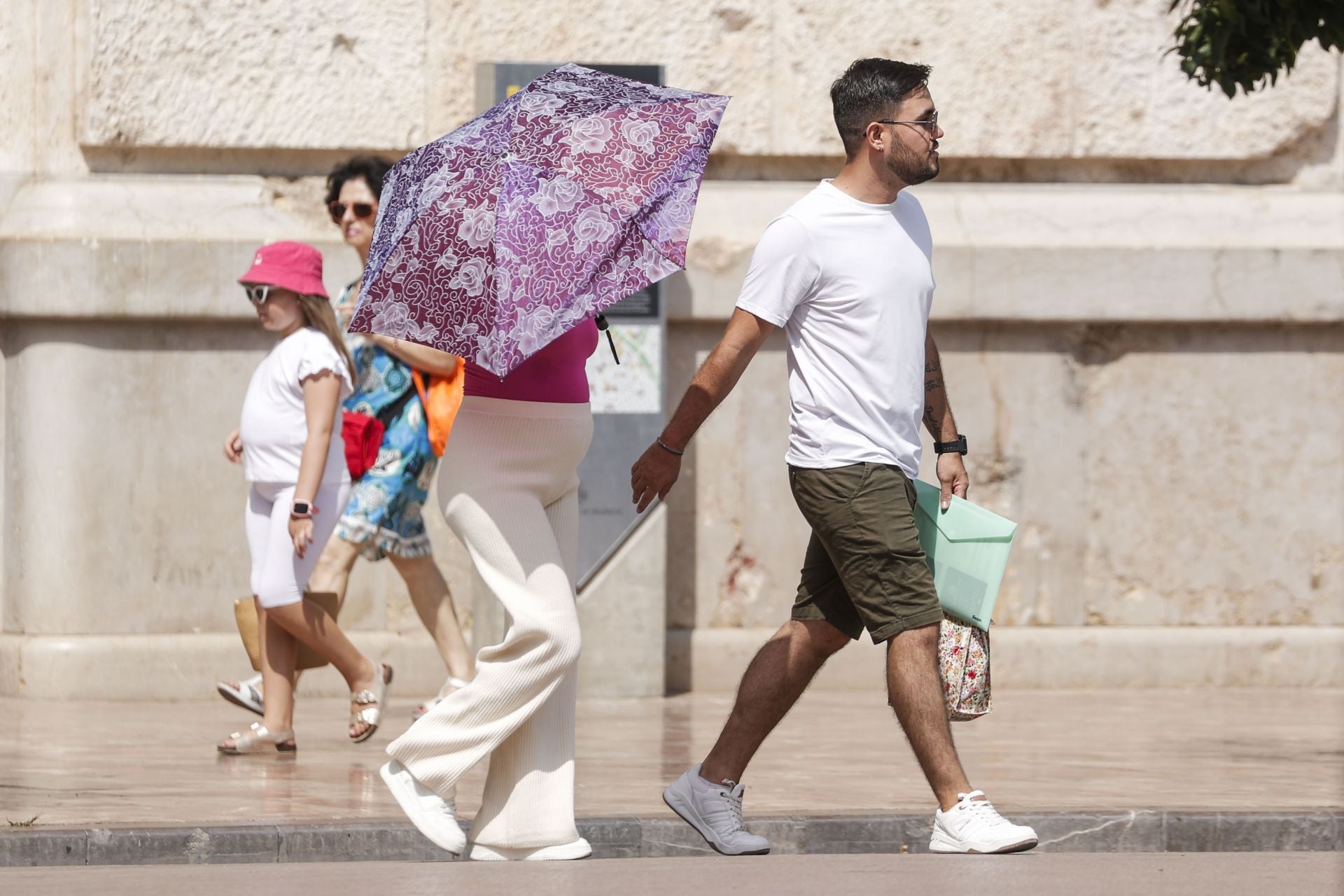 Varias personas caminando este lunes por la plaza del Ayuntamiento de Valencia.