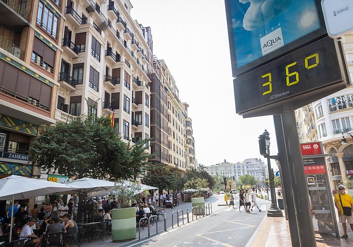 Un termómetro marca la temperatura en la plaza del Ayuntamiento de Valencia, con el cielo encapotado de fondo.