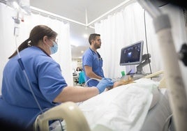 Dos médicos atienden a un paciente.