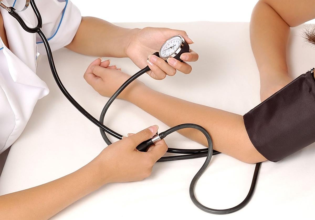 Enfermera toma la tensión arterial de una paciente