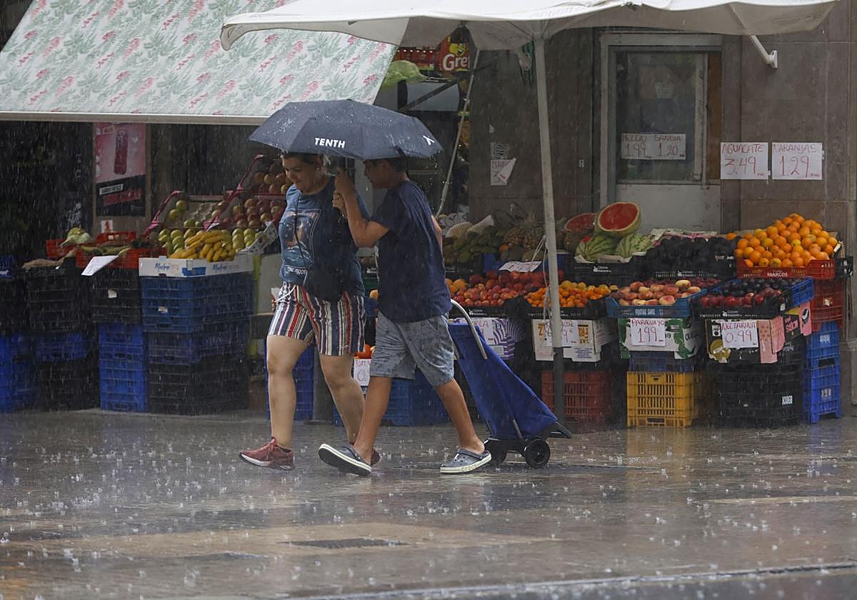 Una pareja se resguarda de las lluvias en Valencia.