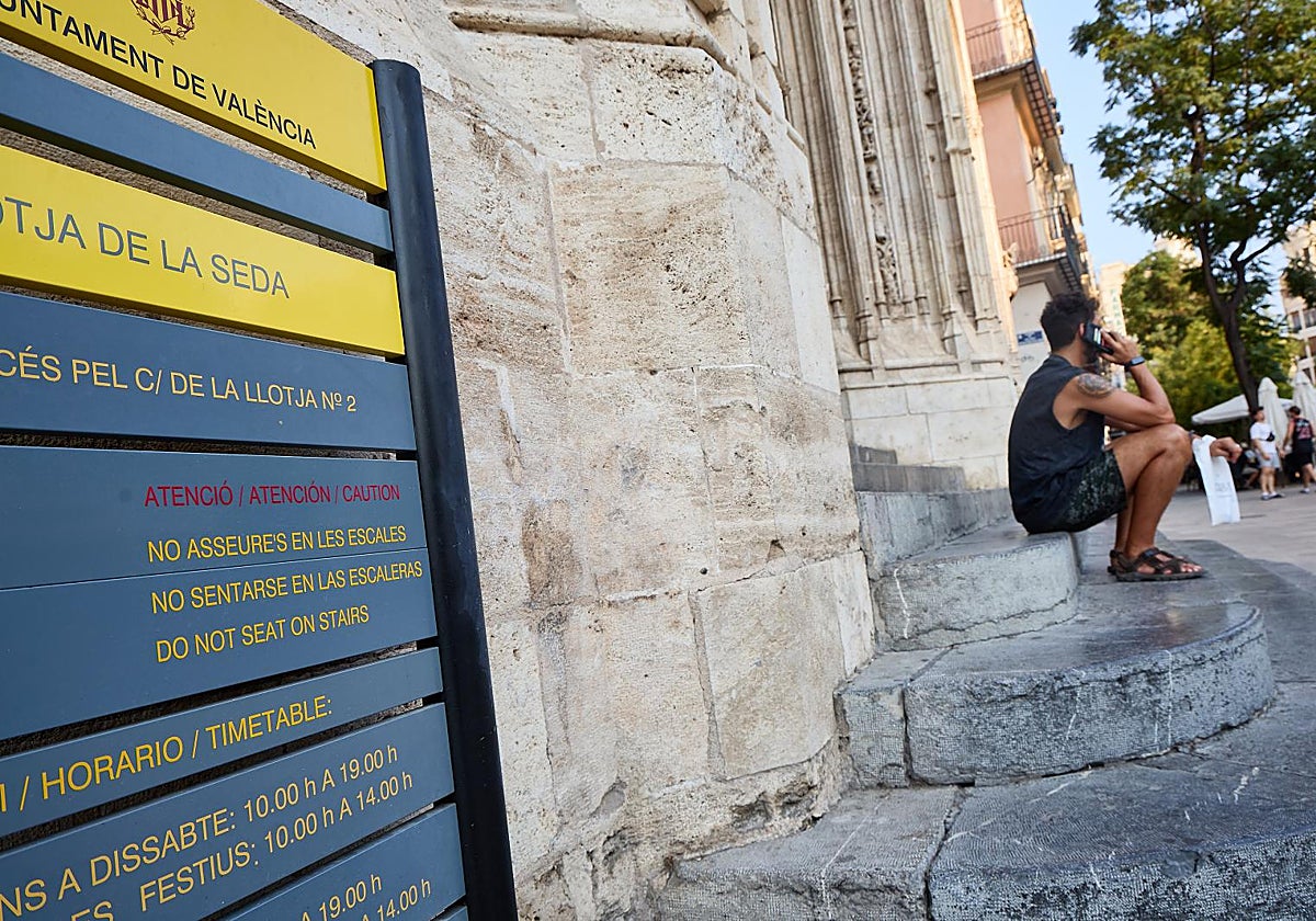 Una persona descansa en las escaleras de la Lonja, esta semana.