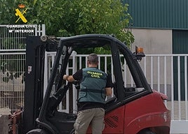 Un agente de la Benérita junto a una de las carretillas recuperadas.