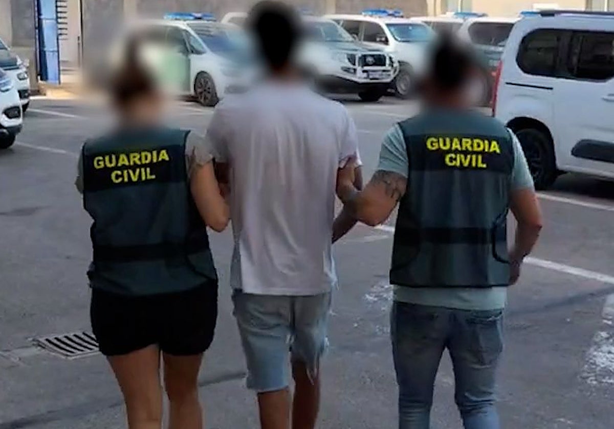 Dos agentes de la Guardia Civil trasladan al sospechoso de la agresión a la anciana en Torrevieja.