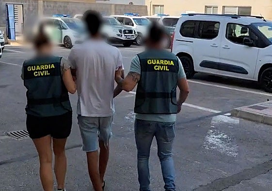Dos agentes de la Guardia Civil trasladan al sospechoso de la agresión a la anciana en Torrevieja.