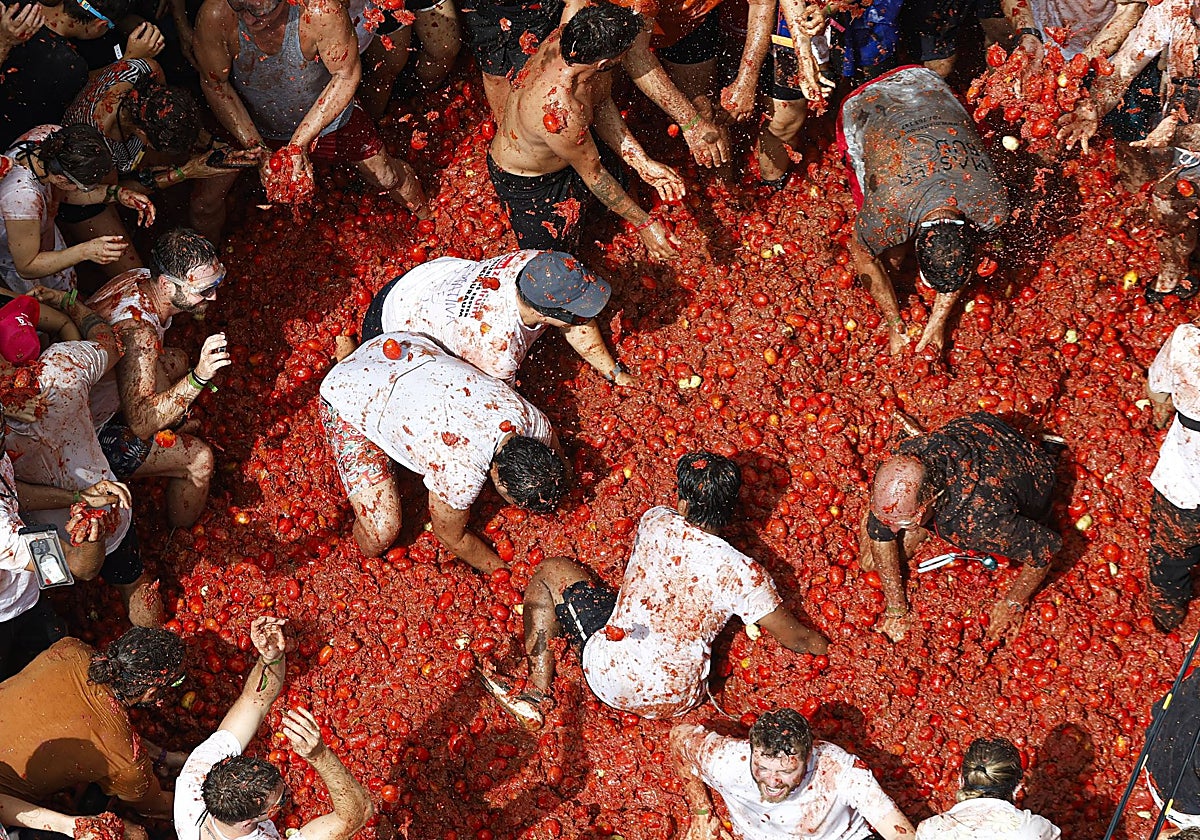 Participantes en la Tomatina se lanzan tomates en un momento de la celebración.