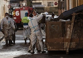 Voluntarios sacan lodo de los bajos de Paiporta.