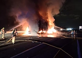 Los bomberos arrojan agua sobre el fuego que destruyó uno de los camiones en la A-7.