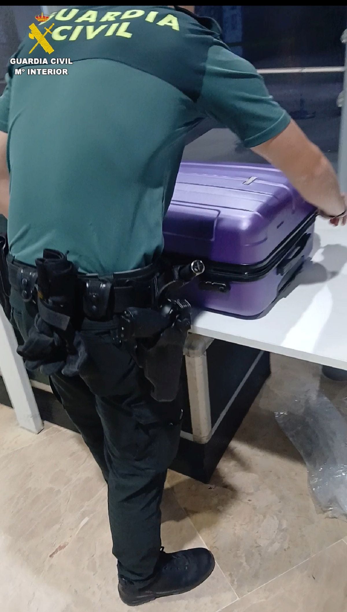 Un agente comprobando una maleta en el aerupouerto.