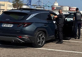 Dos agentes de la Policía Local junto a uno de los coches sustraídos.