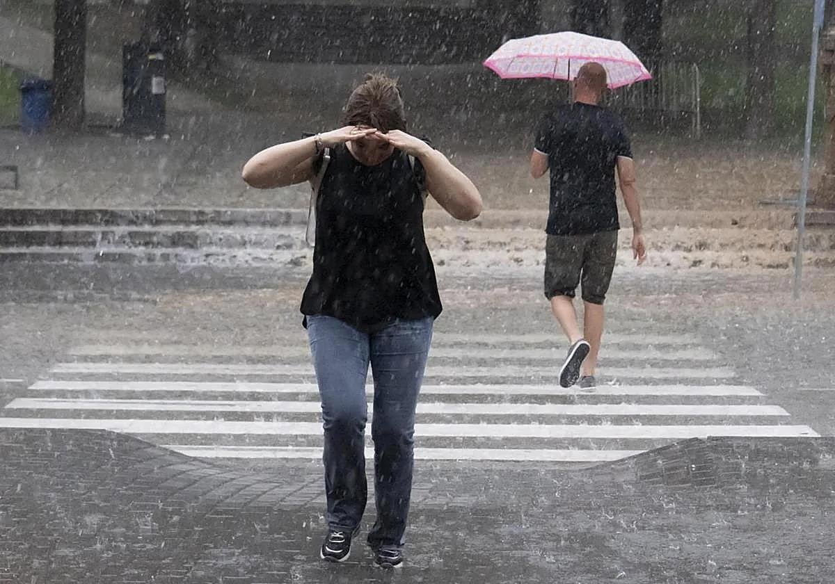 Dos personas se protegen de la lluvia en verano, en una imagen de archivo.