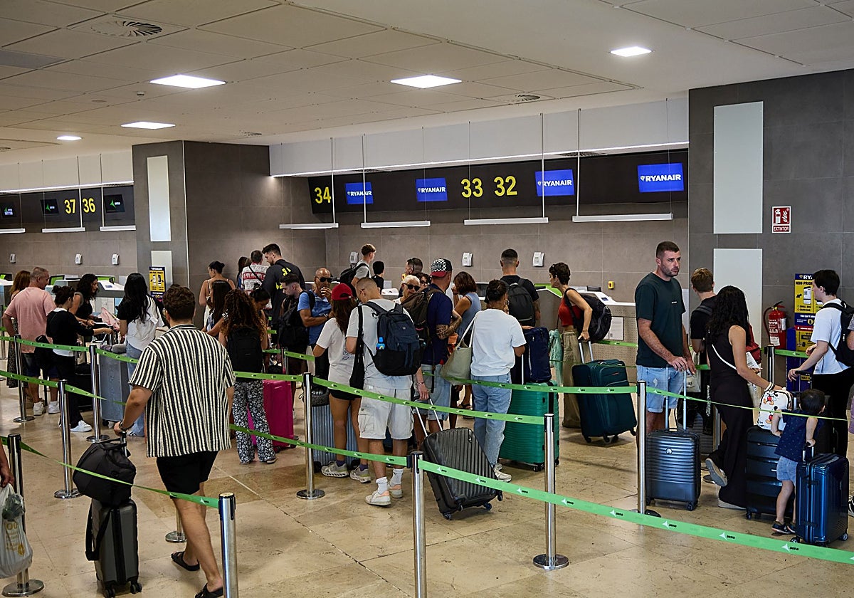 Pasajeros frente a la zona de embarque de maletas de Ryanair en el aeropuerto de Manises.