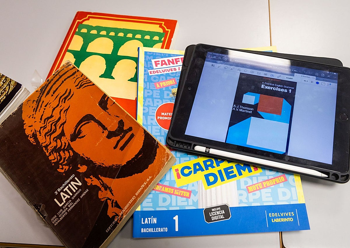 Imagen secundaria 1 - Santi Boix imparte clase desde el portátil. Abajo, la evolución gráfica de algunos libros de Latín y la actual tableta. En la tercera imagen, lo que Juan Antonio llevaba en su mochila a mediados de los ochenta.