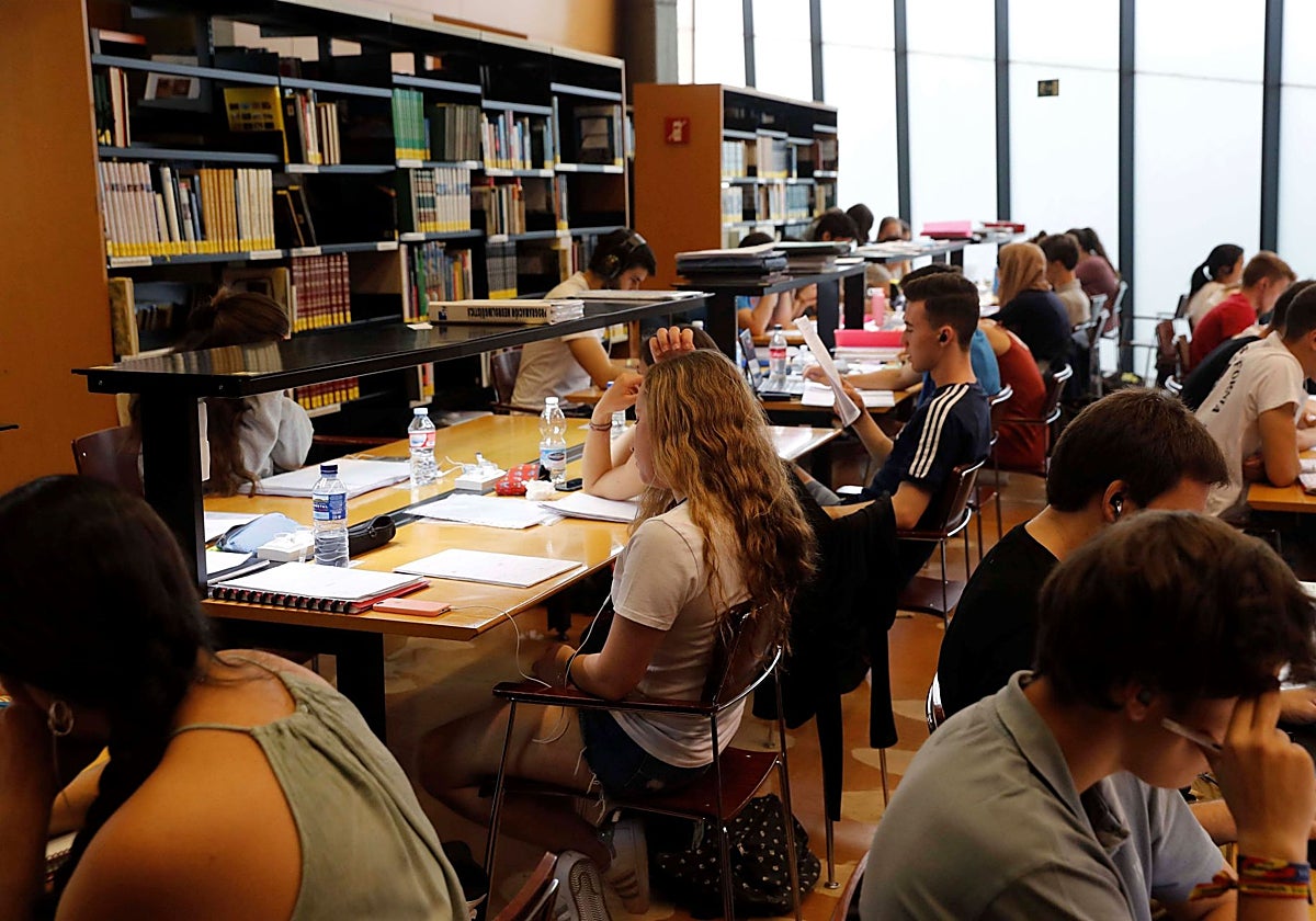 Alumnos estudiando en una biblioteca.
