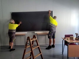 La colocación de una pizarra en el IES Les Salines provisional.