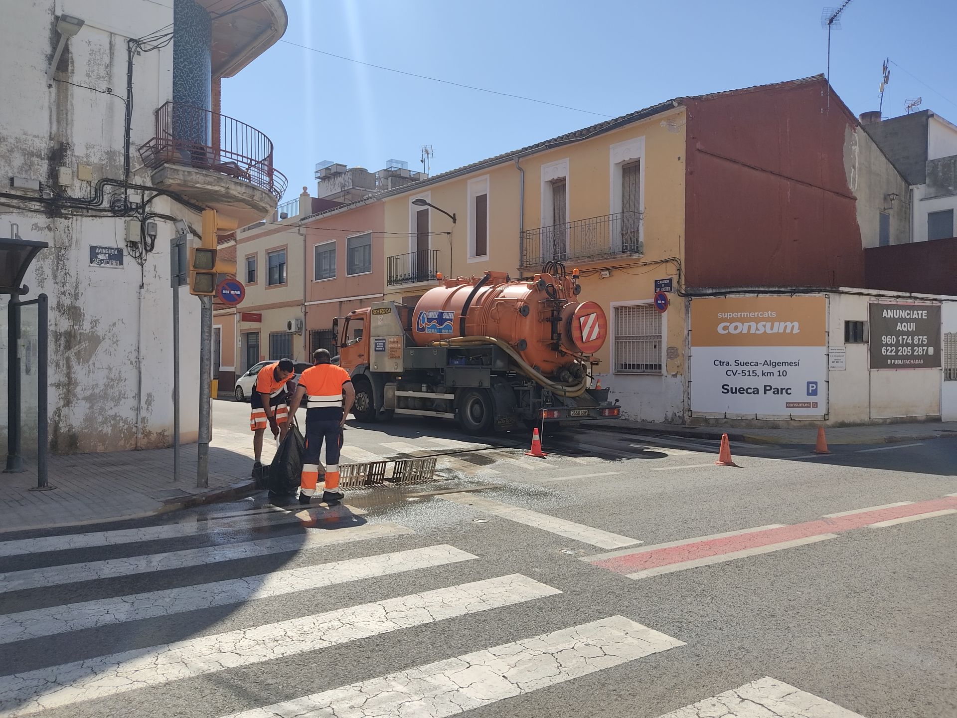 Limpieza de imbornales en una de las calles afectadas en Riola.
