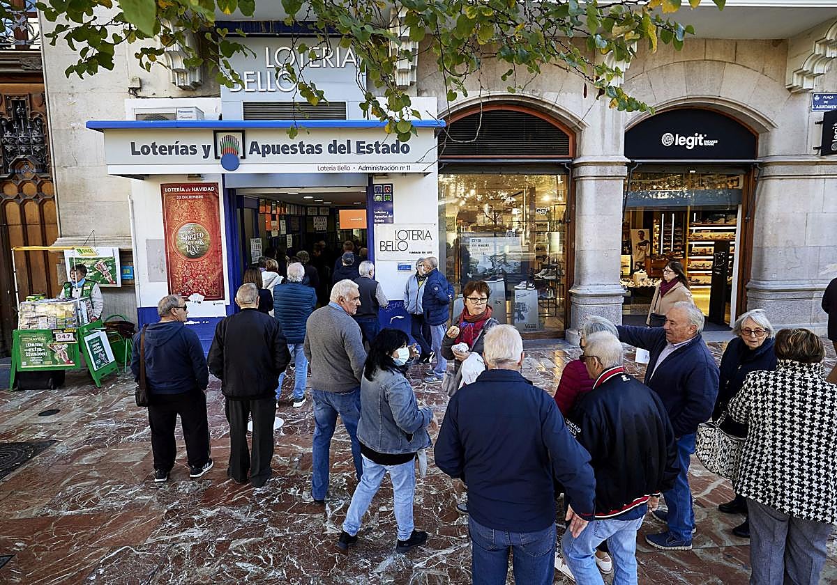 Varios jugadores de Lotería Nacional hacen cola para comprar su décimo, imagen de archivo.