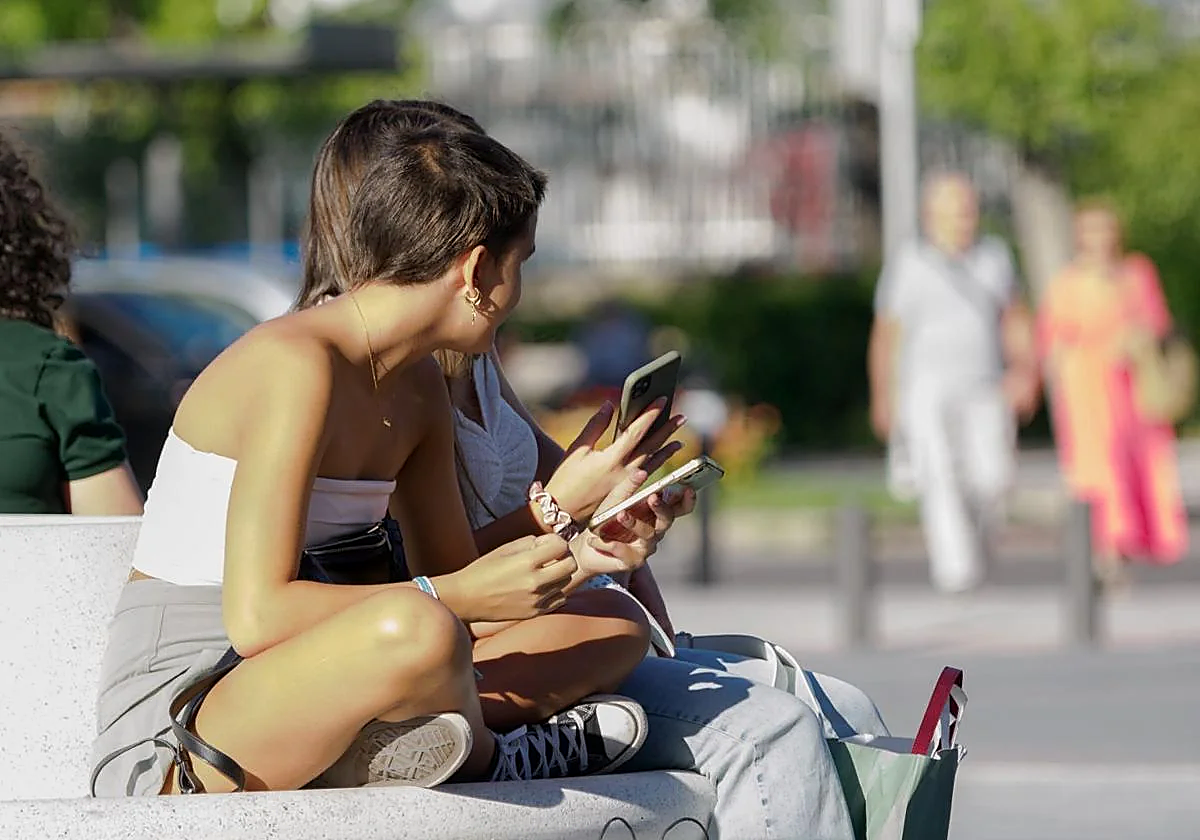 Dos adolescentes en la puerta de un instituto.