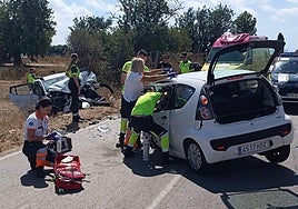 Los sanitarios y guardias civiles asisten a los dos conductores heridos tras el choque frontal.