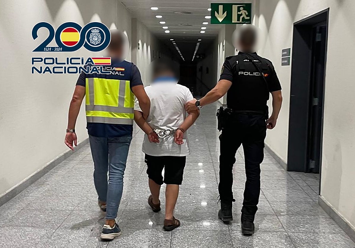 Dos policías trasladan al detenido a un calabozo.