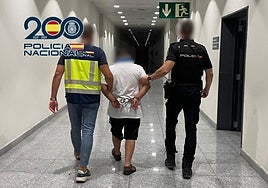 Dos policías trasladan al detenido a un calabozo.