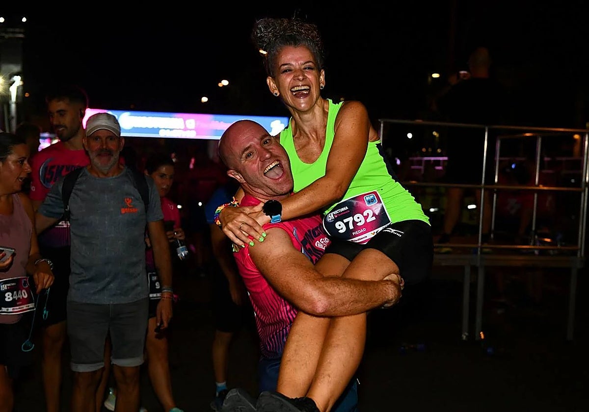 Dos participantes, felices tras finalizar la 15K Nocturna Valencia en 2024.
