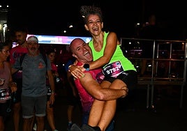 Dos participantes, felices tras finalizar la 15K Nocturna Valencia en 2024.