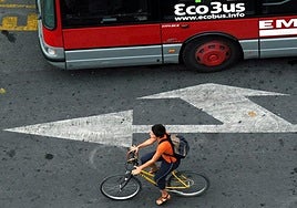 Un ciclista pasa junto a un autobus en Valencia, en una imagen de archivo.