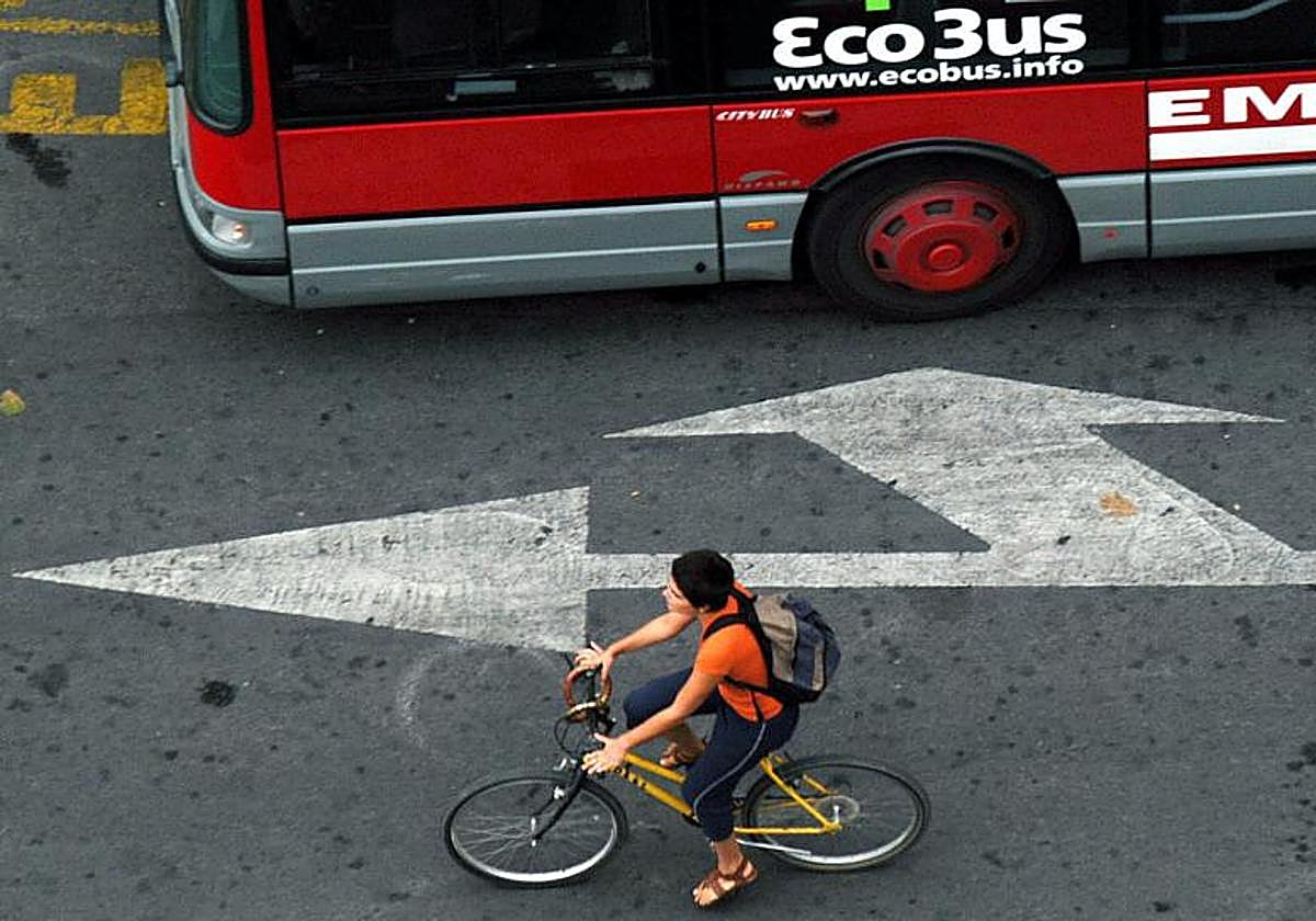 Un ciclista pasa junto a un autobus en Valencia, en una imagen de archivo.