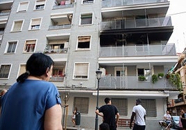 Unos vecinos observan los destrozos que causó el incendio en esta finca de la calle Padre Viñas.