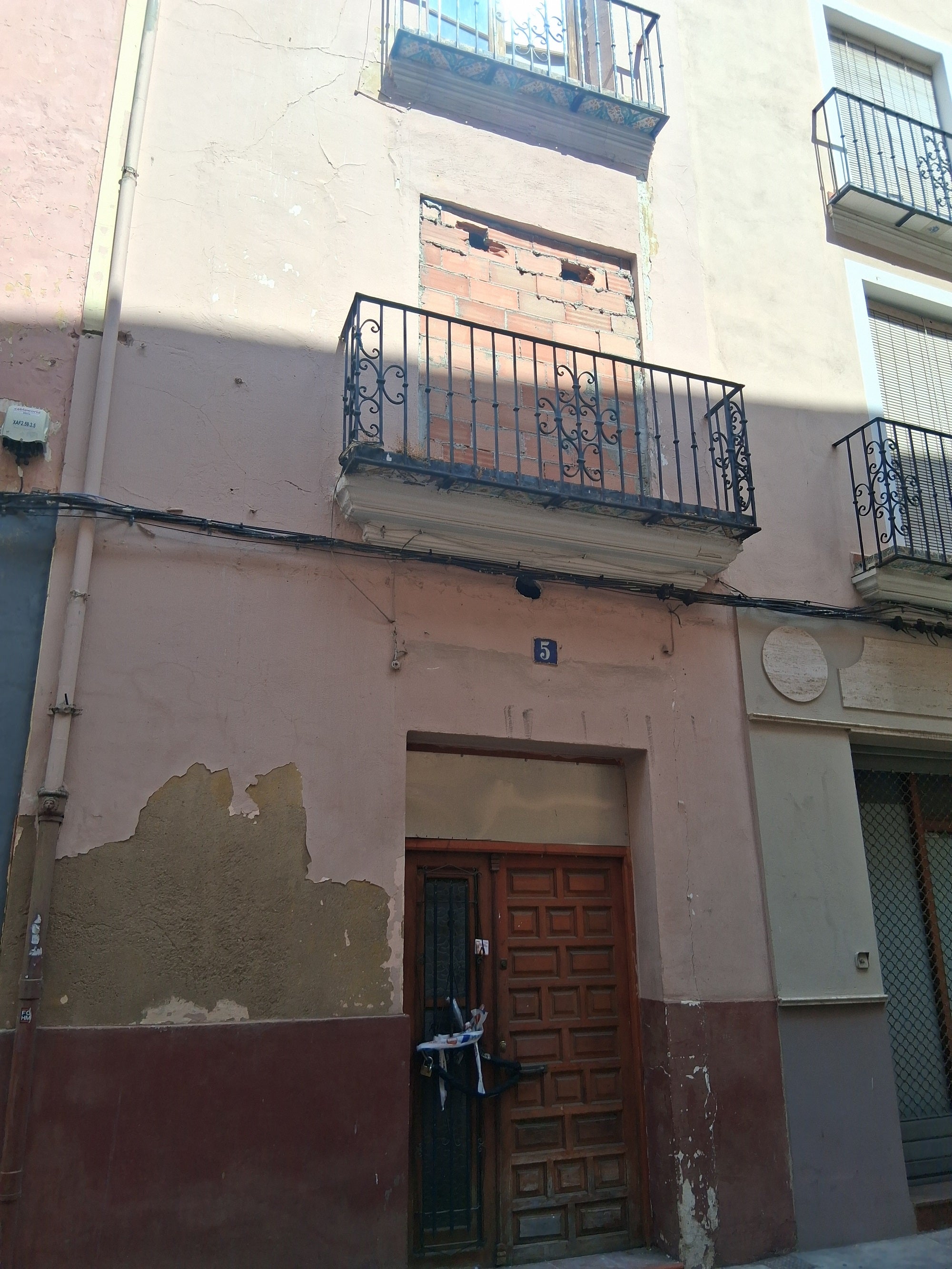 Imagen secundaria 2 - Arriba, la puerta del Palau por donde intentaron entrar, ahora con vigas para cerrar el hueco. Abajo, varias casas precintadas por la Policía y tapiadas para evitar la ocupación.