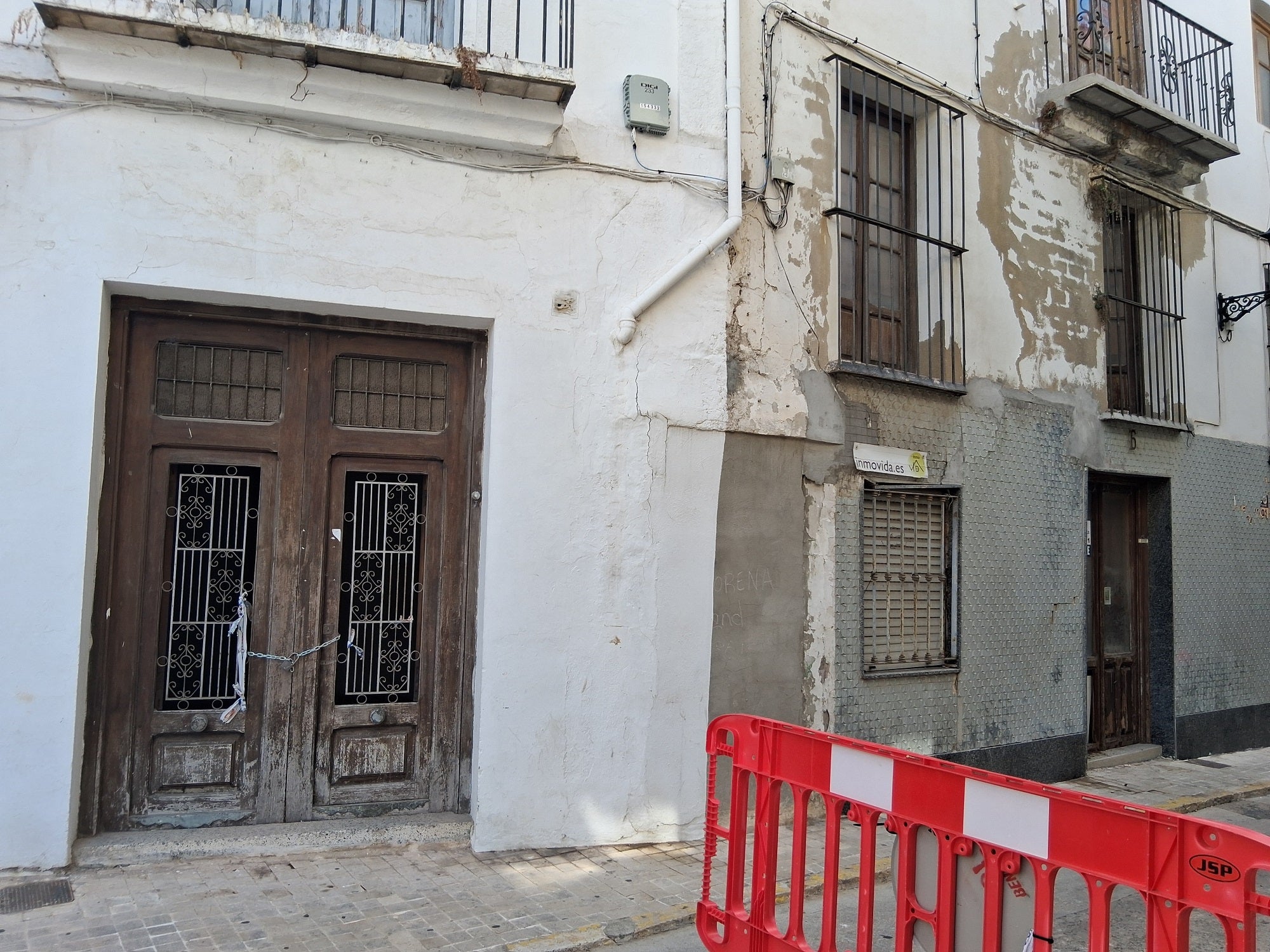 Imagen secundaria 1 - Arriba, la puerta del Palau por donde intentaron entrar, ahora con vigas para cerrar el hueco. Abajo, varias casas precintadas por la Policía y tapiadas para evitar la ocupación.