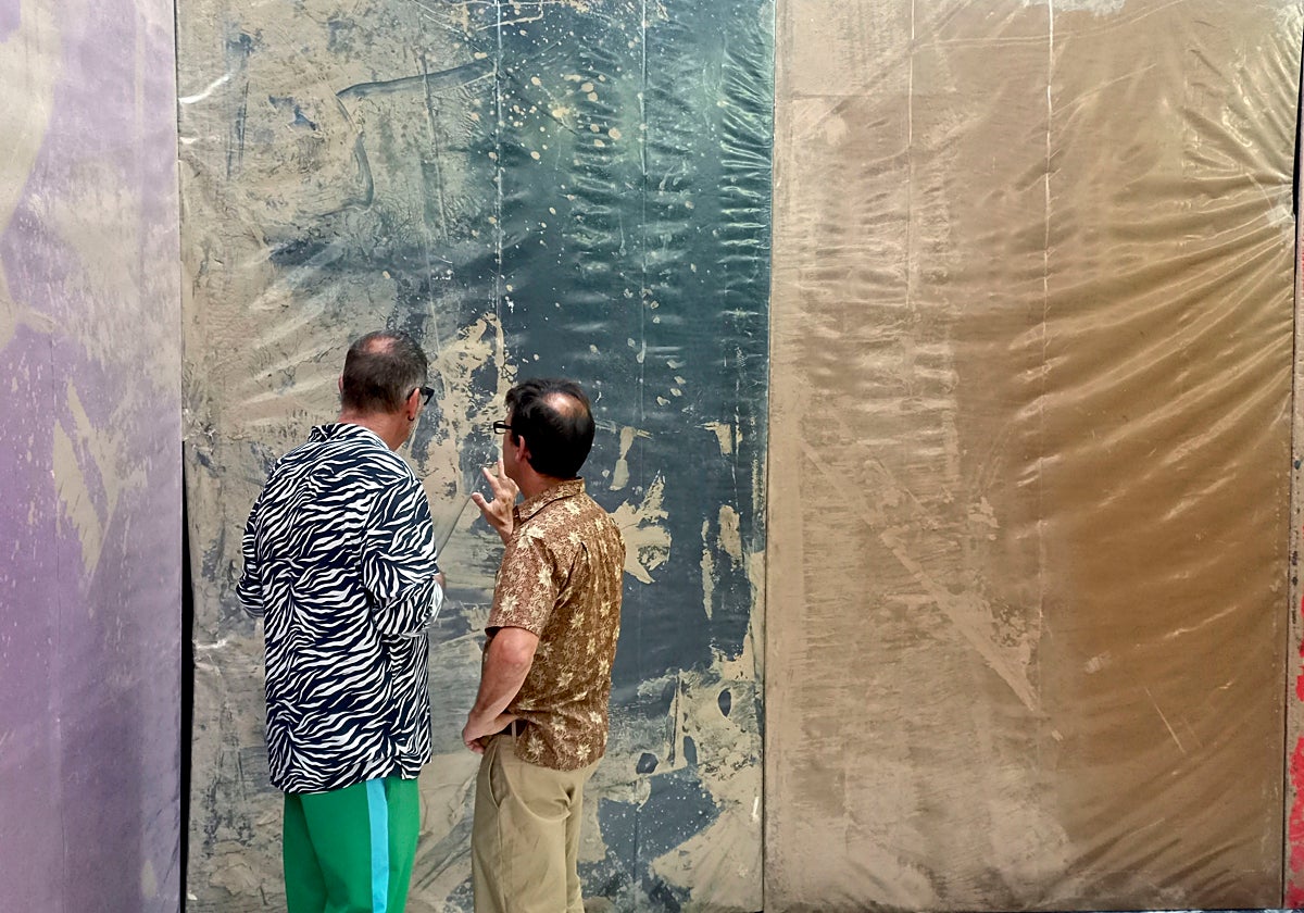 Hugo Martínez-Tormo observa una de sus obras con un visitante a la exposición en Tarragona.