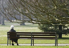 Una anciana, en una banco, en una imagen de archivo.
