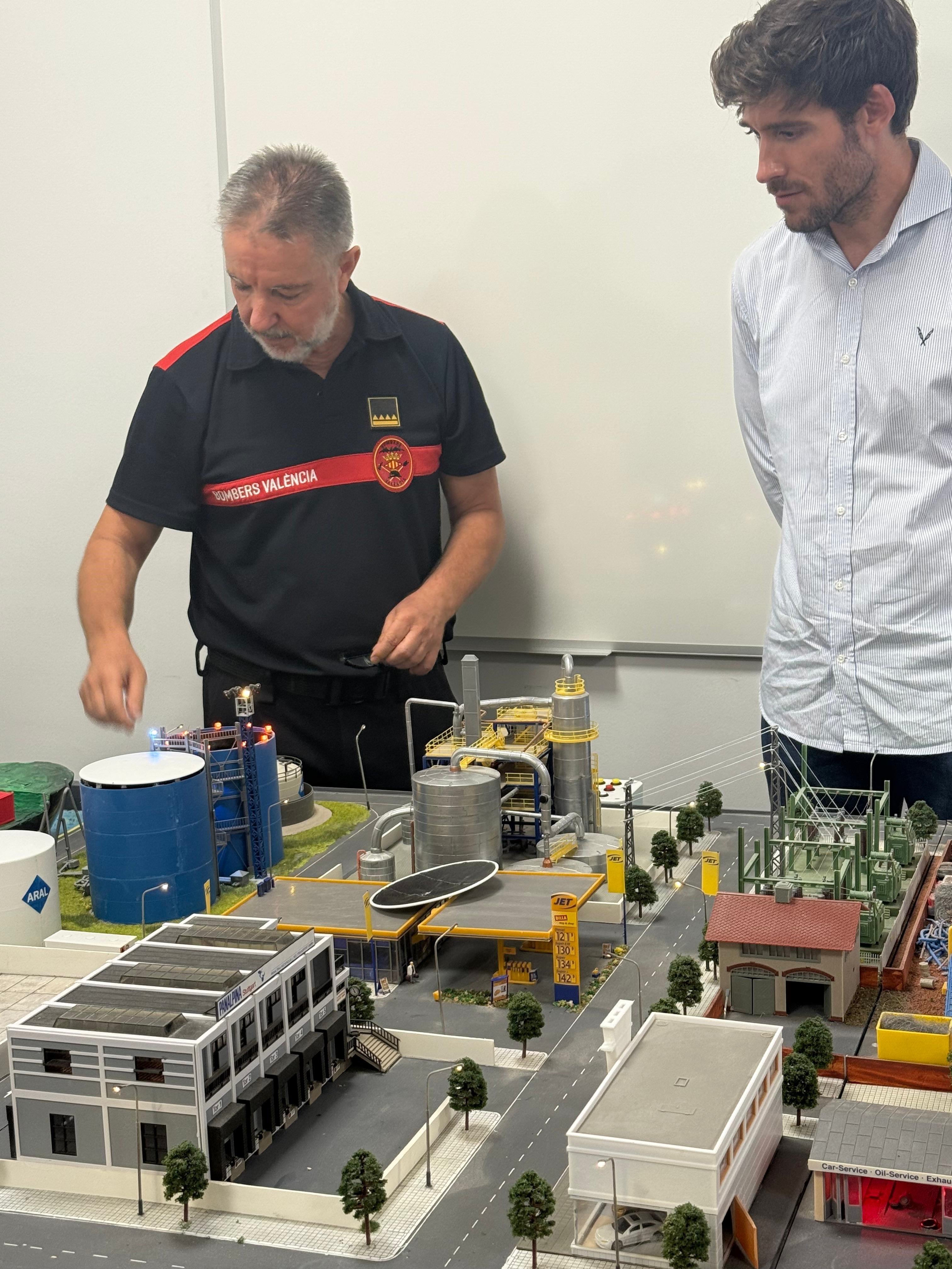 El concejal de Emergencias. Juan Carlos Caballero, contempla la maqueta junto a un mando de los bomberos.