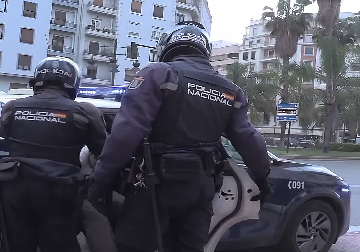 Los agentes, con el detenido en el interior del vehículo.